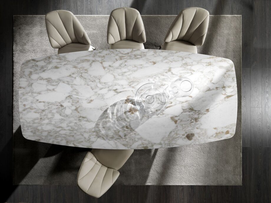 Elite chair | DV home. Luxurious swivel armchair with quilted back and polished stainless steel base, blending Art Deco elegance with contemporary comfort.