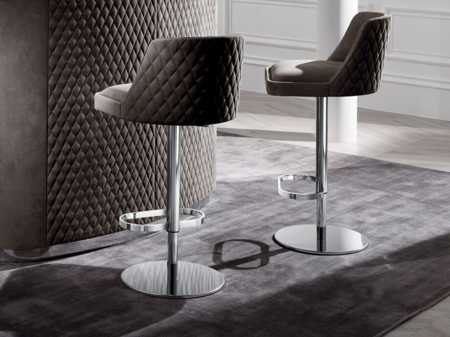 Byron bar chair | DV home. Adjustable height stool with a solid wood structure and stainless steel base, featuring a luxurious quilted back.