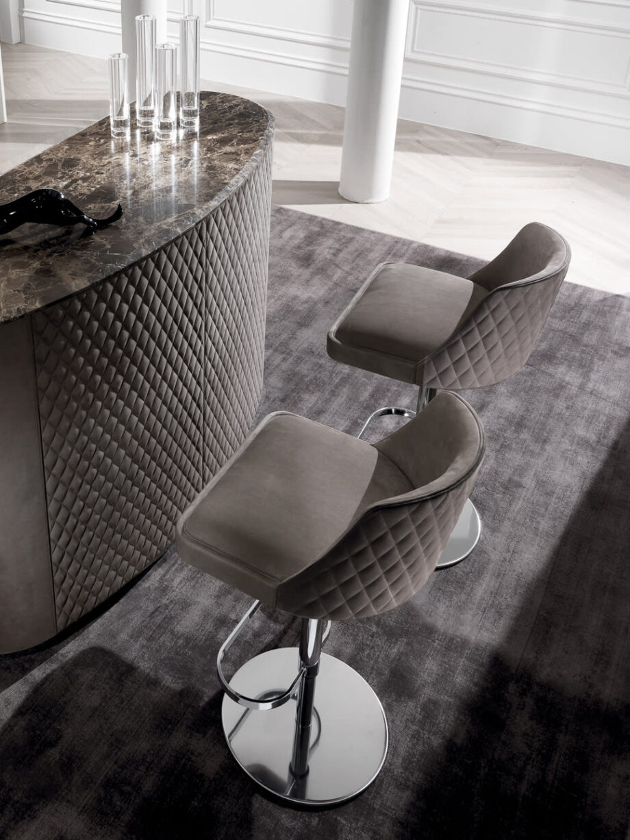 Byron bar chair | DV home. Adjustable height stool with a solid wood structure and stainless steel base, featuring a luxurious quilted back.
