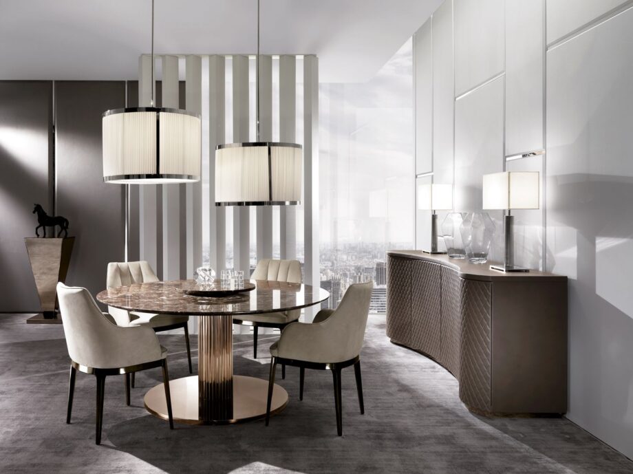 Douglas Round table | DV home. An iconic round table featuring a fluted metal base and a choice of luxurious marble or lacquered wood tops, epitomizing Italian luxury design.