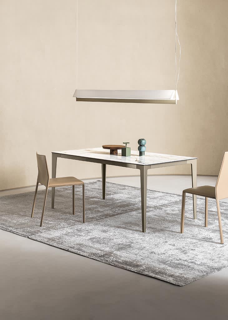 Jag table | ALF Dafre. Elegant, extendable table featuring a metal base and a wood or ceramic top.