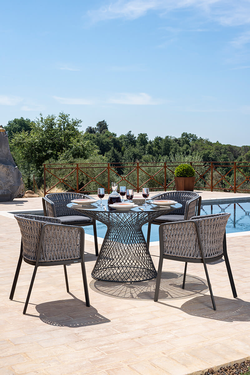 Carousel Outdoor chair | Emu. Elegant, weather-resistant armchair with woven rope detail, aluminum frame, and comfortable cushion for outdoor use.