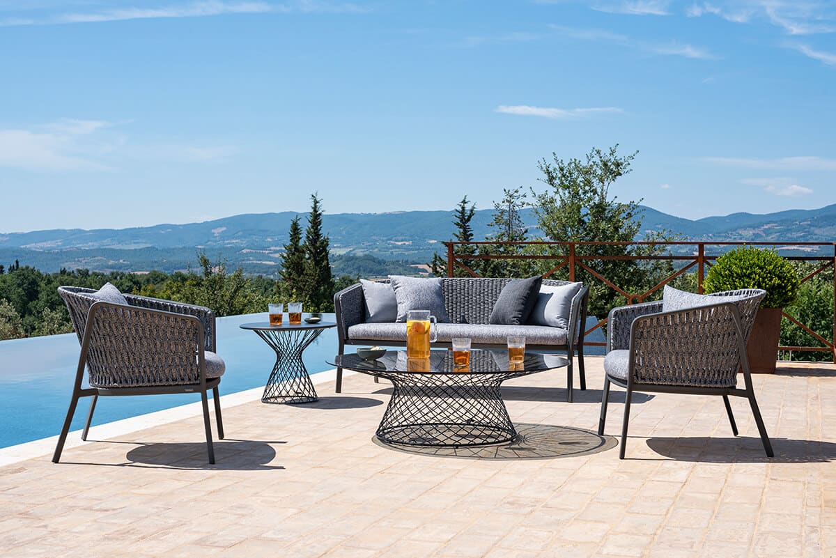 Carousel Outdoor chair | Emu. Elegant, weather-resistant armchair with woven rope detail, aluminum frame, and comfortable cushion for outdoor use.