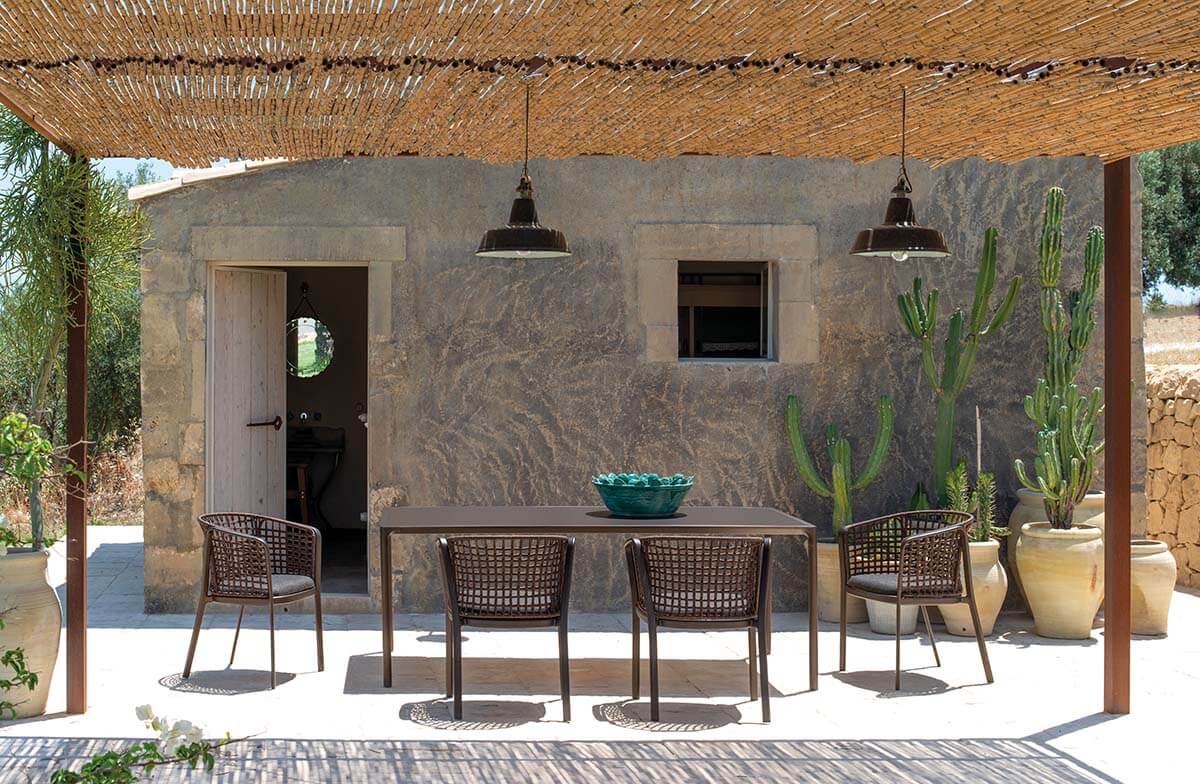 Carousel Outdoor chair | Emu. Elegant, weather-resistant armchair with woven rope detail, aluminum frame, and comfortable cushion for outdoor use.