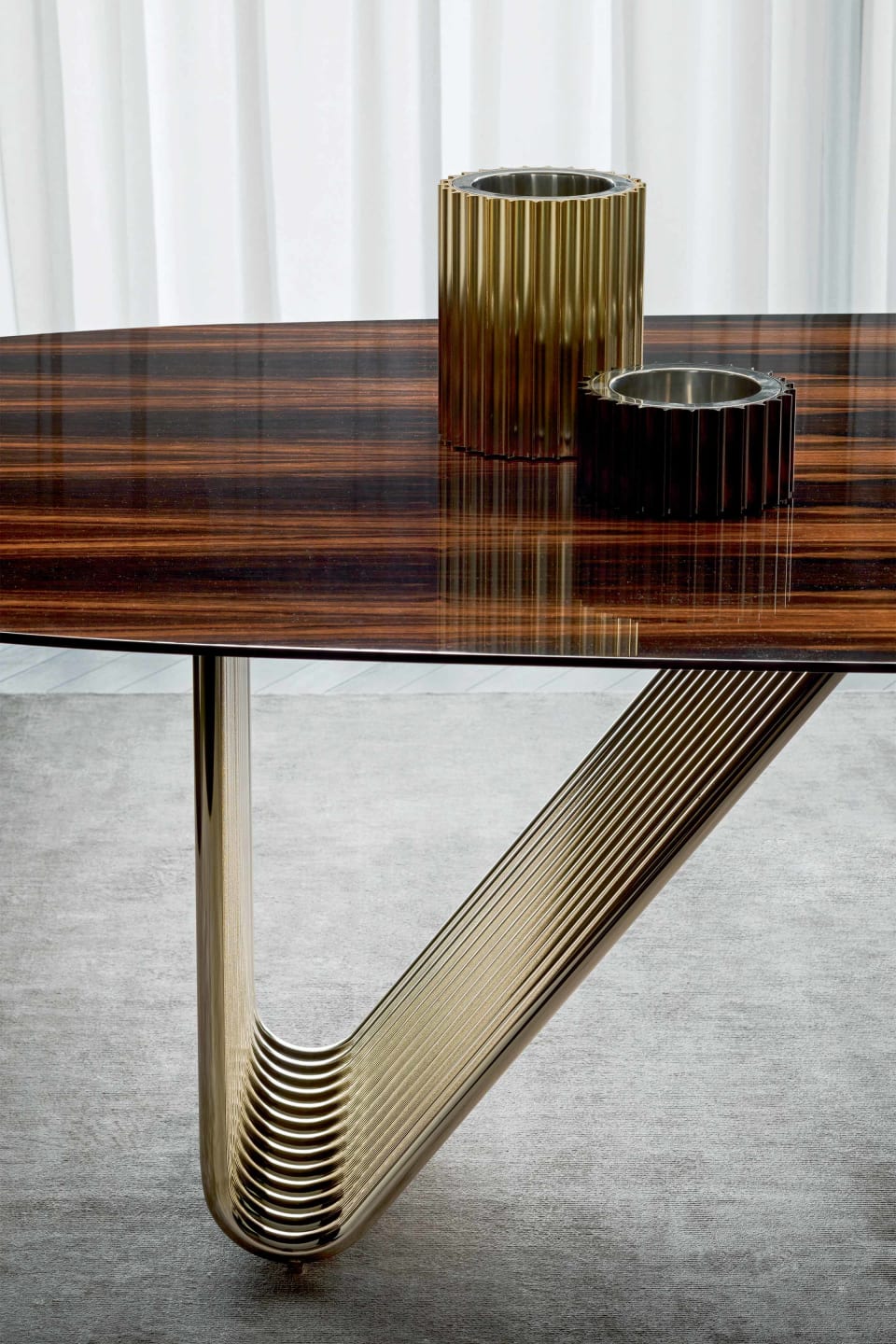 Alyson table | Rugiano. Elegant dining table with curved metal base and versatile top options in wood, marble, glass, or leather.