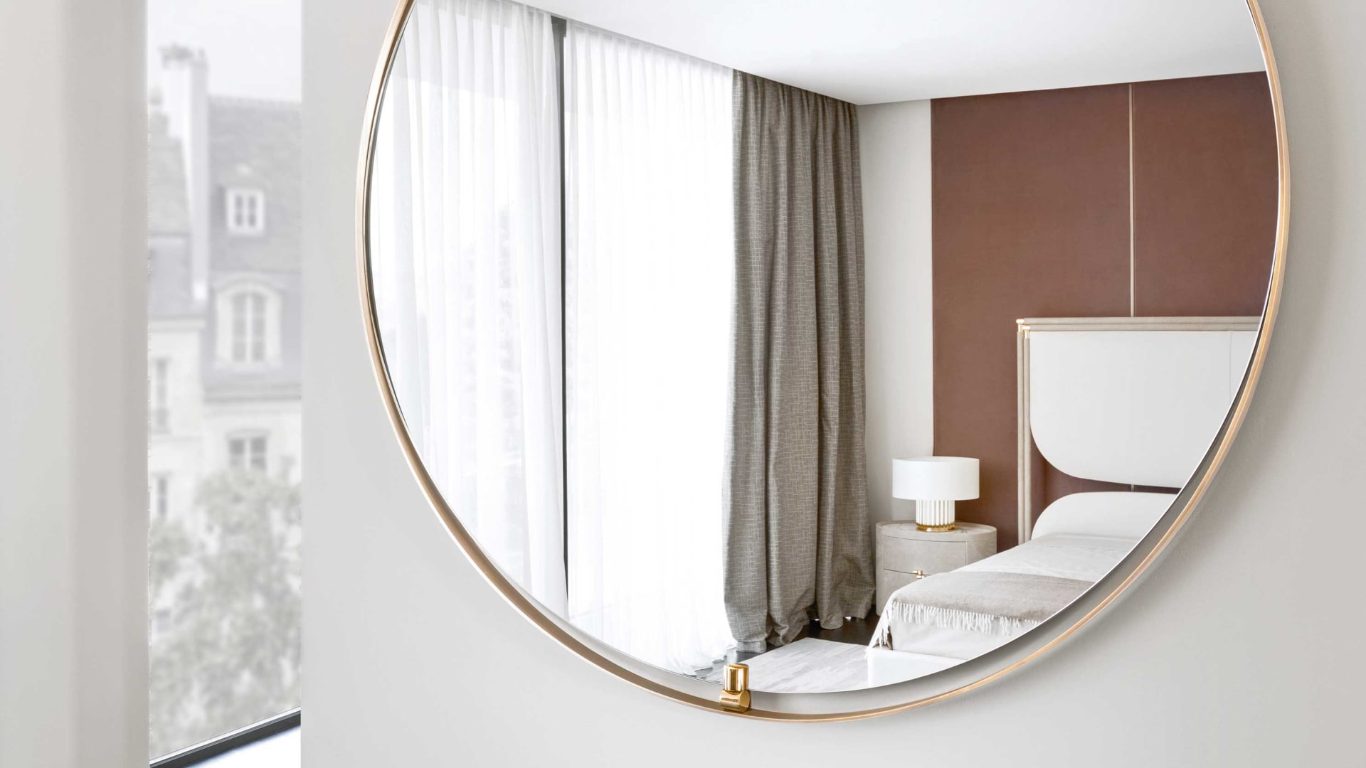 Ofelia mirror | Rugiano. Round designer mirror with a luxurious bronze frame and glossy brass details, blending Art Deco and modern styles.