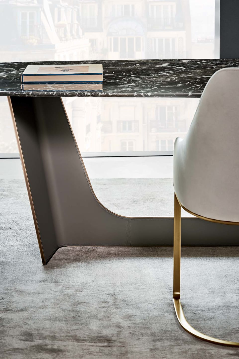 Wings table | Rugiano. Elegant dining table with an upholstered metal base and a versatile oval top in marble, wood, or hand-painted finishes.