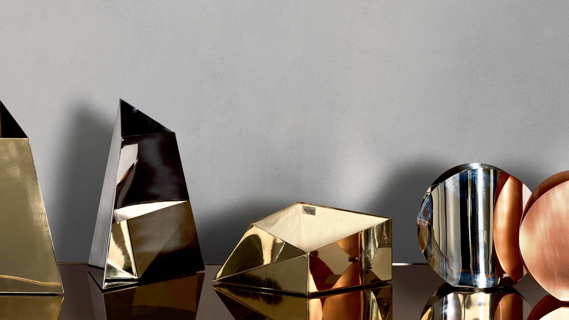 Prisma decorative object | Rugiano. Exquisite geometric decorative object crafted from polished metal, creating a captivating play of light and reflections.