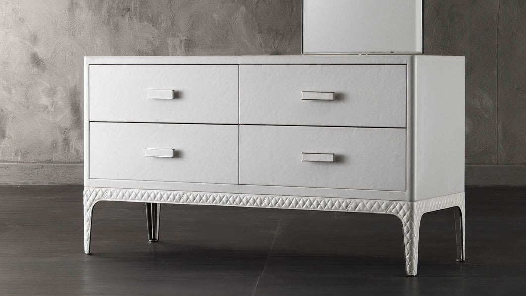 Dorian chest of drawers | Rugiano. A luxurious, high-end chest of drawers with sleek lines and a distinctive metal base, offering sophisticated storage and an optional integrated mirror.