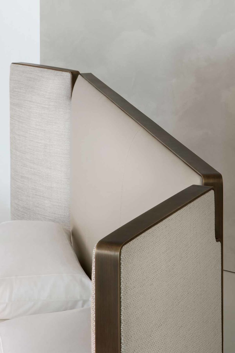 Falcon bed | Rugiano. Sculptural bed with integrated side wings and refined bronze detail, offering customizable luxury and deep comfort.