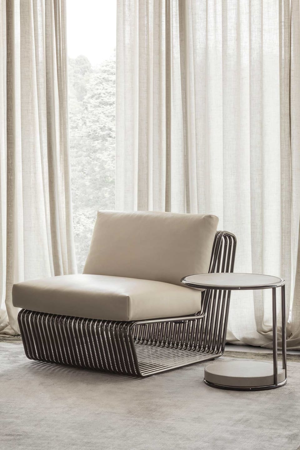 Infinity armchair | Rugiano. A sculptural piece with a sinuous shape and luxurious metal accents, offering unparalleled style and comfort.