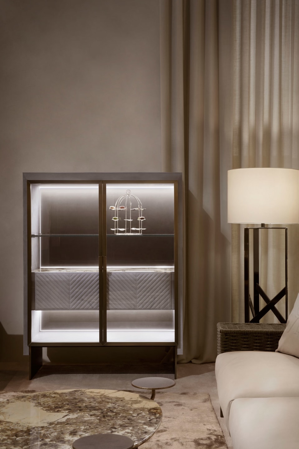 Iole sideboard | Rugiano. Luxurious sideboard with leather upholstery, bronze details, marble top with backlighting, and elegant glass doors.