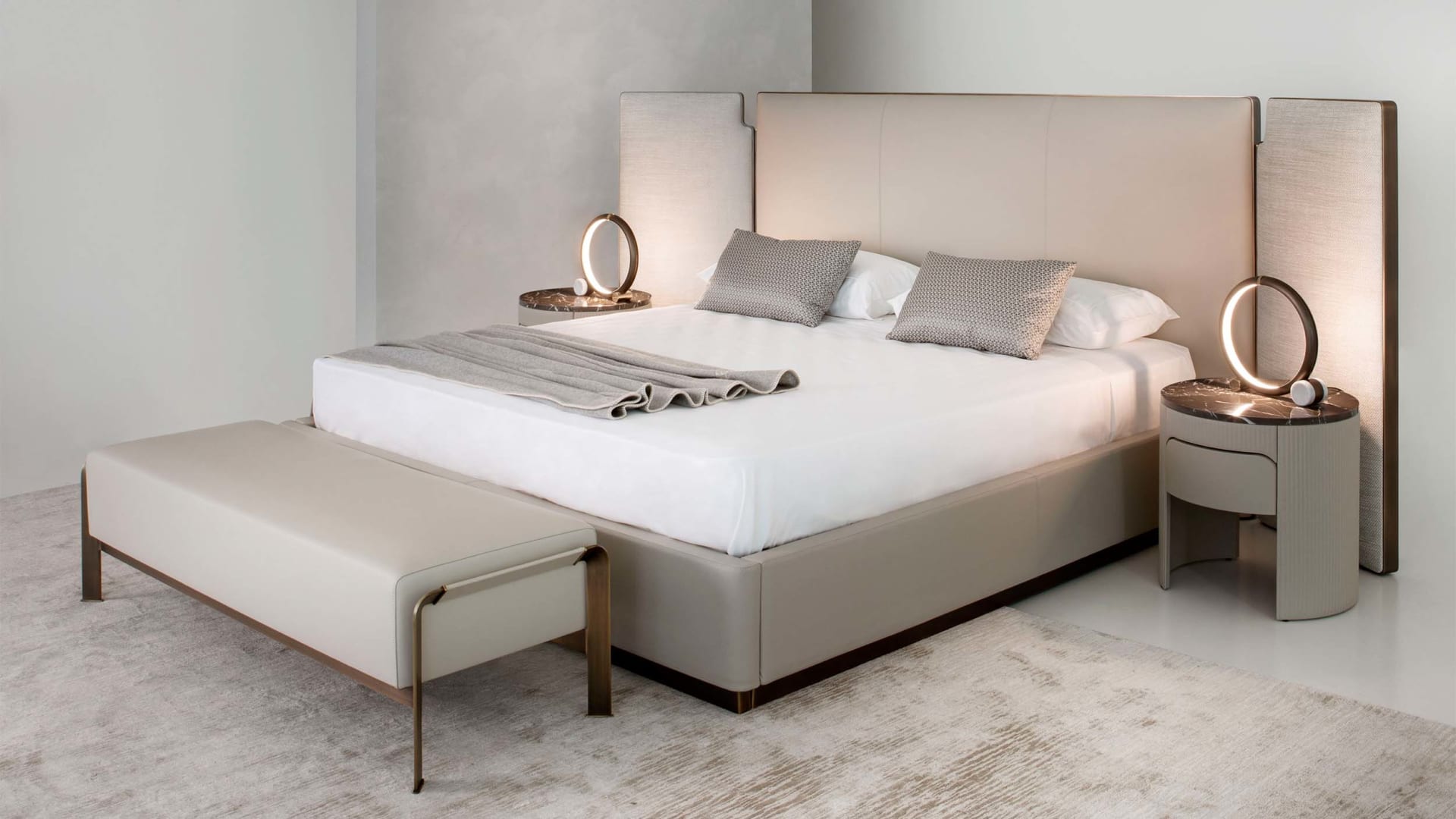 Falcon bed | Rugiano. Sculptural bed with integrated side wings and refined bronze detail, offering customizable luxury and deep comfort.
