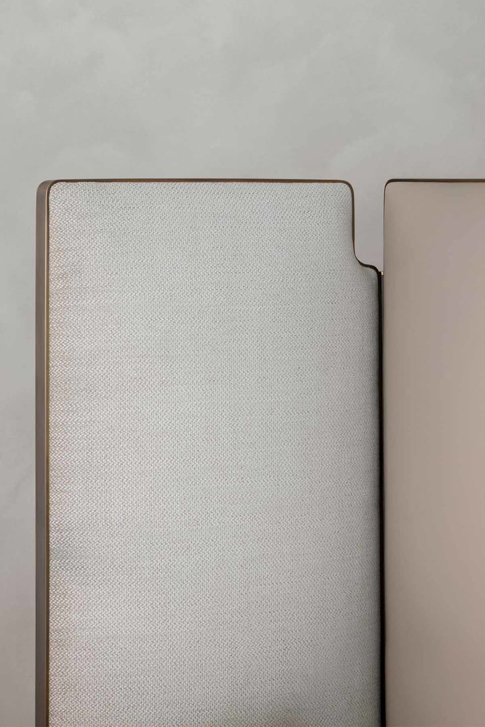 Falcon bed | Rugiano. Sculptural bed with integrated side wings and refined bronze detail, offering customizable luxury and deep comfort.