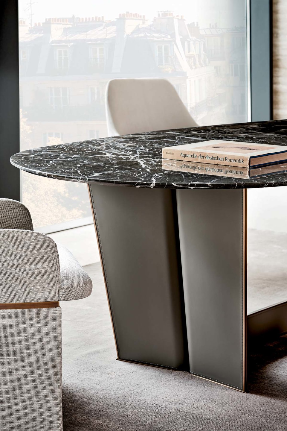 Wings table | Rugiano. Elegant dining table with an upholstered metal base and a versatile oval top in marble, wood, or hand-painted finishes.