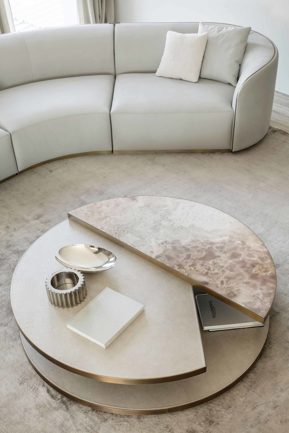 Moon coffee table | Rugiano. A luxurious round coffee table featuring exquisite marble and leather or ebony tops, complemented by elegant bronze profiles.