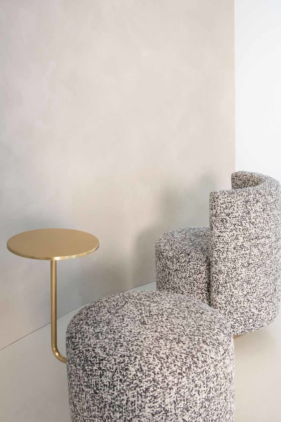 Harry pouf | Rugiano. Versatile upholstered poufs with elegant satin gold details, available in classic, armrest, and integrated side table designs.