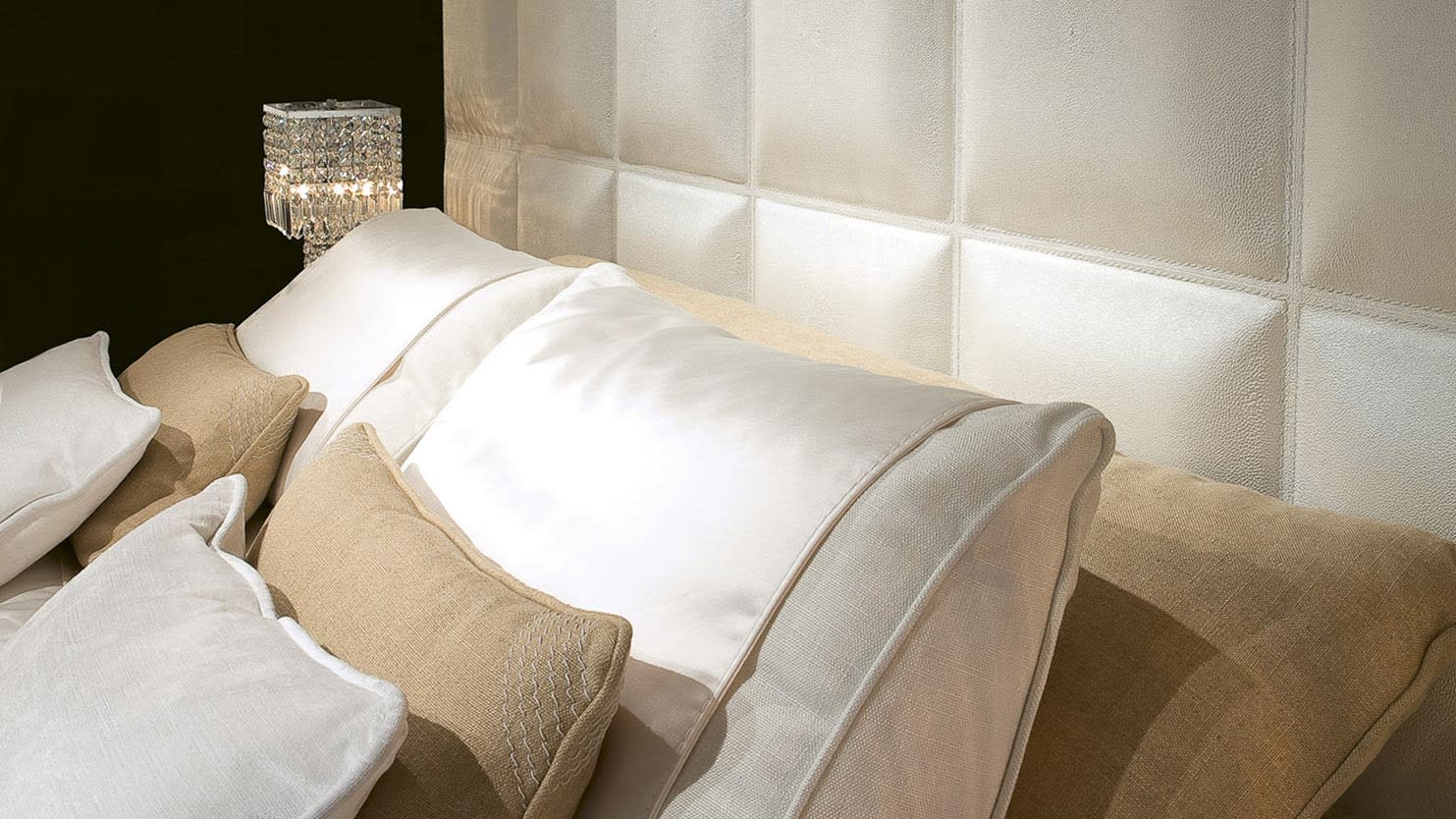 Gemma bed | Rugiano. Elegant bed featuring a high tufted headboard and optional integrated nightstands, creating a luxurious bedroom ambiance.