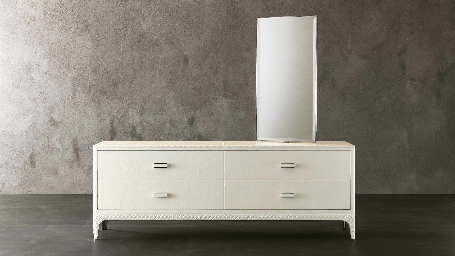 Dorian chest of drawers | Rugiano. A luxurious, high-end chest of drawers with sleek lines and a distinctive metal base, offering sophisticated storage and an optional integrated mirror.