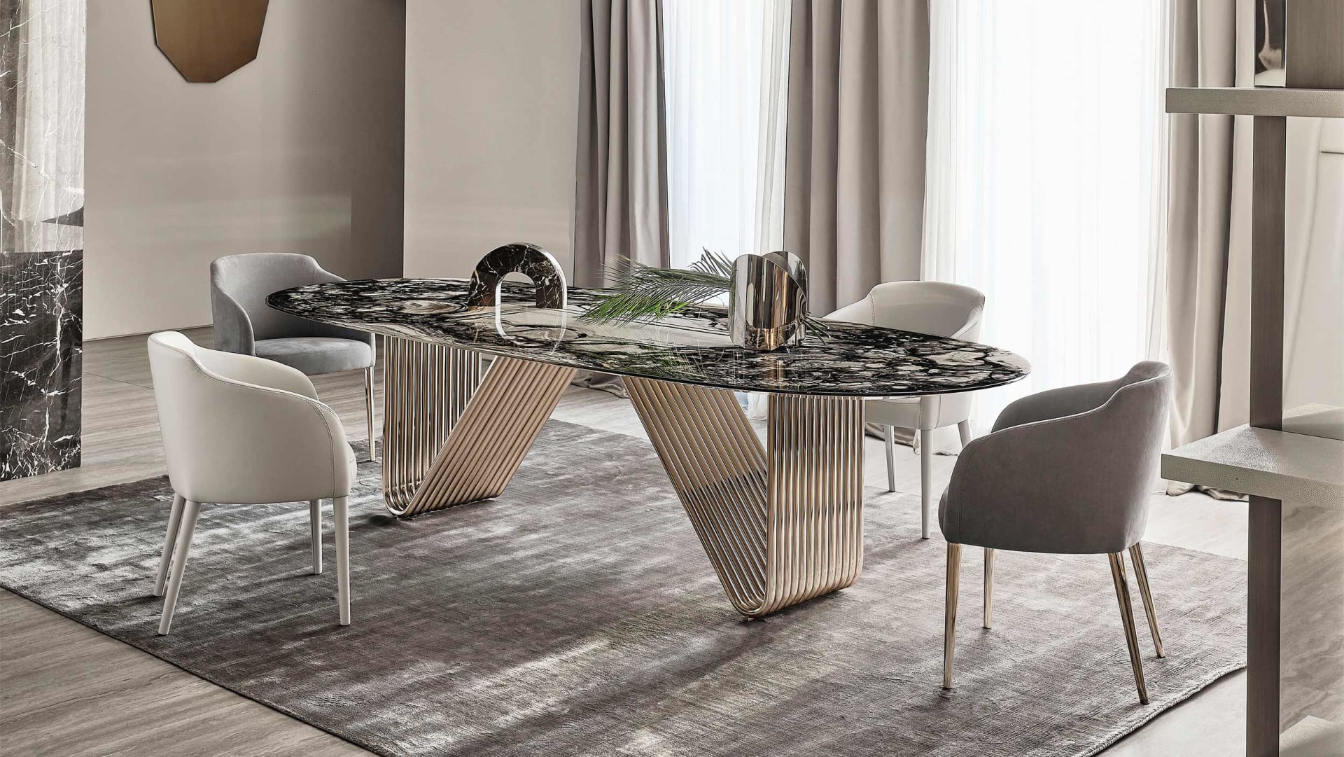 Alyson table | Rugiano. Elegant dining table with curved metal base and versatile top options in wood, marble, glass, or leather.