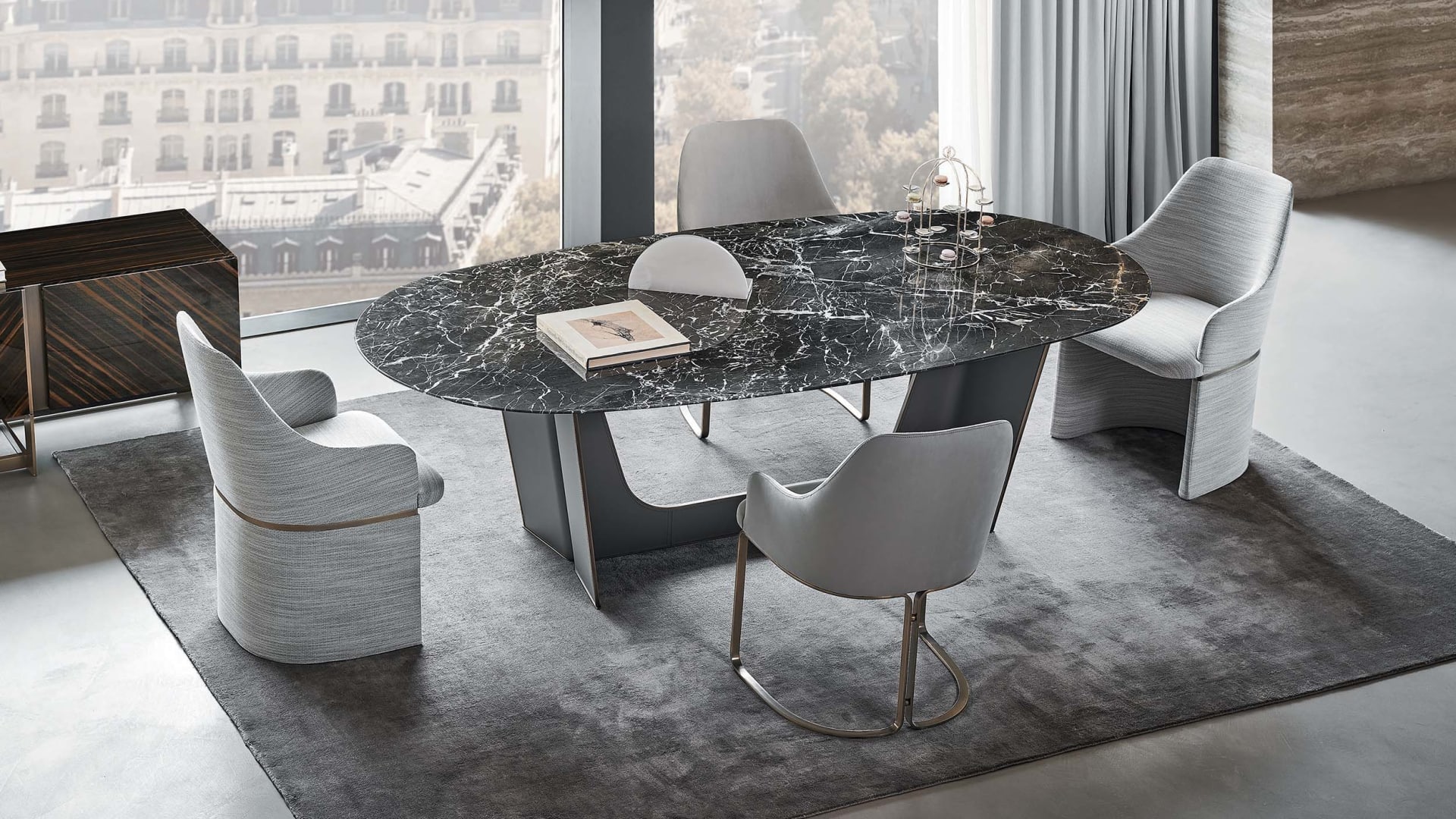 Wings table | Rugiano. Elegant dining table with an upholstered metal base and a versatile oval top in marble, wood, or hand-painted finishes.